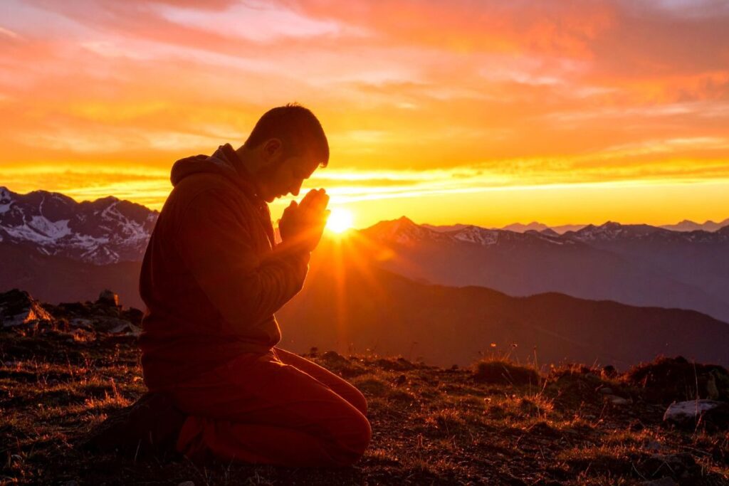 Homem orando ao amanhecer entregando ansiedade e preocupações a Deus no devocional matinal