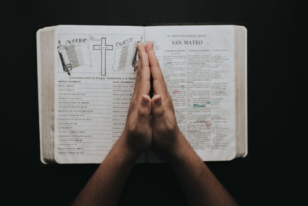 Mãos em oração sobre Bíblia aberta durante devocional para combater ansiedade e preocupações